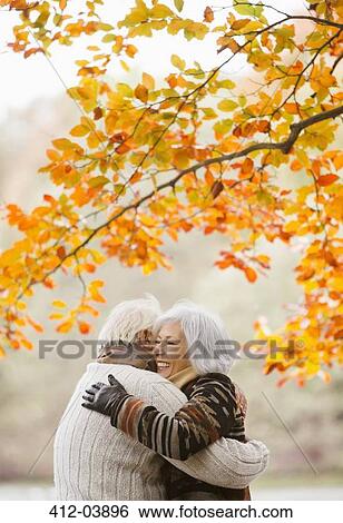 Older couple hugging in park View Large Photo Image Stock Photograph - Older couple hugging in park. Fotosearch