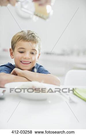 Smiling boy having spaghetti at table View Large Photo Image Stock Photo - Smiling boy having spaghetti at table. Fotosearch