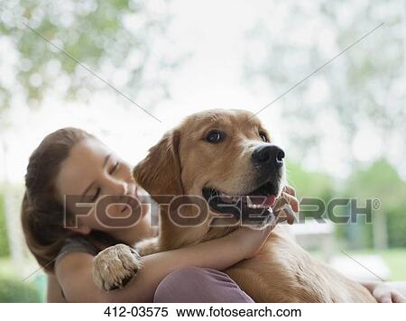 Smiling girl hugging dog outdoors View Large Photo Image Stock Photography - Smiling girl hugging dog outdoors. Fotosearch