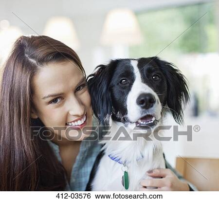 Smiling woman hugging dog indoors View Large Photo Image Stock Photograph - Smiling woman hugging dog indoors. Fotosearch