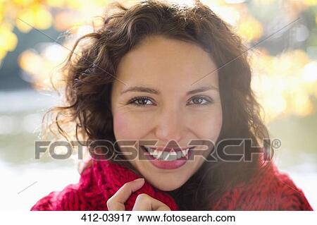 Smiling woman standing in park View Large Photo Image Stock Photo - Smiling woman standing in park. Fotosearch