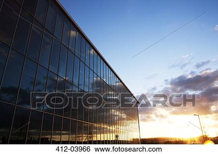 Stock Photograph - Sunrise sky reflected in modern building windows. Fotosearch