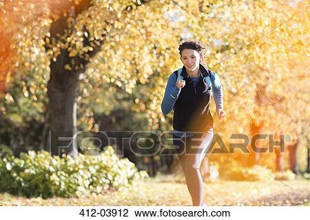 Stock Image - Woman running in park. Fotosearch