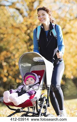 Woman running with baby stroller in park View Large Photo Image Picture - Woman running with baby stroller in park. Fotosearch