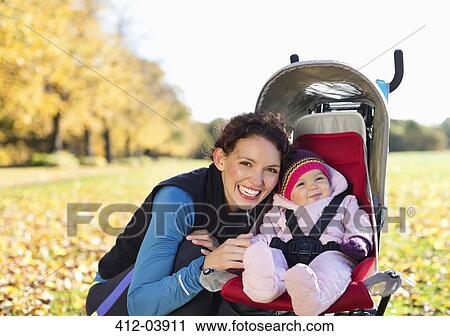 Woman smiling with baby in stroller View Large Photo Image Stock Image - Woman smiling with baby in stroller. Fotosearch