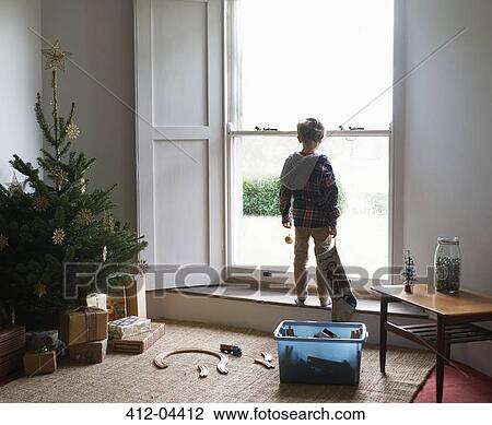 Boy holding Christmas stocking at window View Large Photo Image Stock Image - Boy holding Christmas stocking at window. Fotosearch
