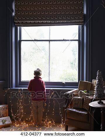 Boy playing with Christmas lights View Large Photo Image Stock Photo - Boy playing with Christmas lights. Fotosearch