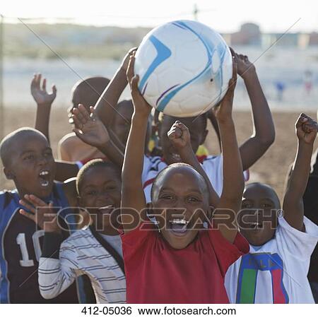 Boys playing soccer together in dirt field View Large Photo Image Stock Photograph - Boys playing soccer together in dirt field. Fotosearch