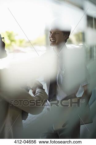Stock Photograph - Business people shaking hands in office. Fotosearch