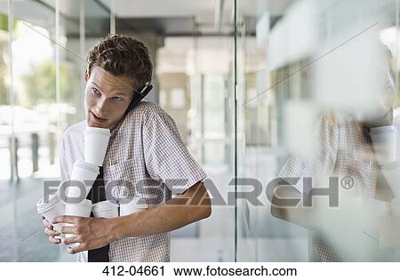Businessman balancing coffees in office View Large Photo Image Stock Image - Businessman balancing coffees in office. Fotosearch