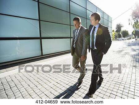 Stock Photo - Businessmen walking on city street. Fotosearch