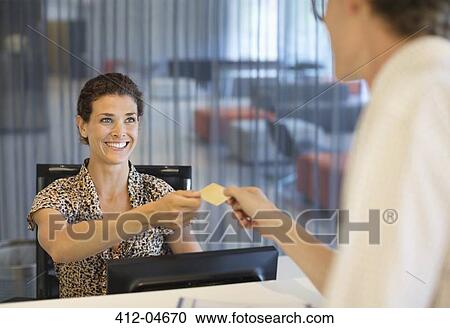 Businesswoman handing credit card to co-worker View Large Photo Image Stock Image - Businesswoman handing credit card to co-worker. Fotosearch