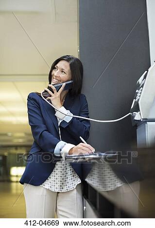 Businesswoman talking on pay phone outdoors View Large Photo Image Stock Photo - Businesswoman talking on pay phone outdoors. Fotosearch