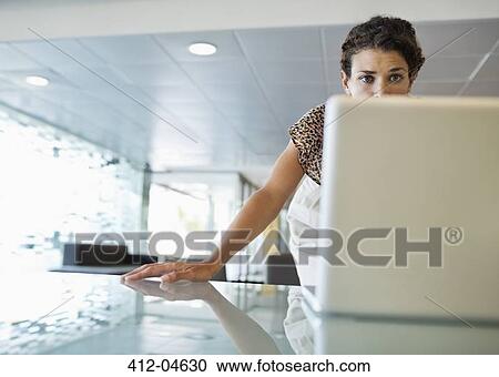 Businesswoman working on laptop at desk View Large Photo Image Stock Image - Businesswoman working on laptop at desk. Fotosearch