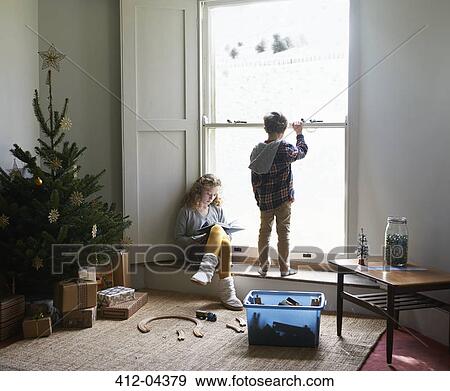 Stock Photo - Children in living room with Christmas tree. Fotosearch