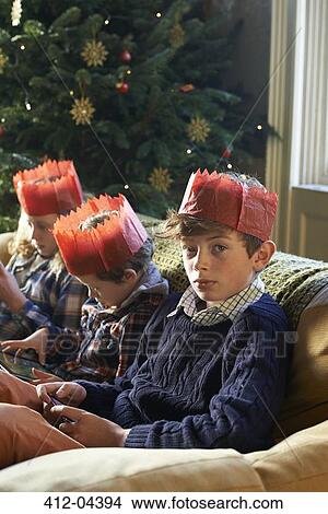 Children in paper crowns relaxing on sofa View Large Photo Image Picture - Children in paper crowns relaxing on sofa. Fotosearch