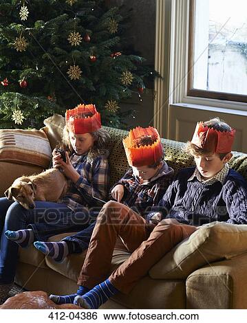 Children in paper crowns relaxing on sofa View Large Photo Image Stock Photograph - Children in paper crowns relaxing on sofa. Fotosearch