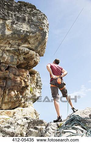 Climber examining rock formation View Large Photo Image Stock Photography - Climber examining rock formation. Fotosearch