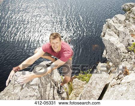 Climber scaling coastal cliff View Large Photo Image Stock Image - Climber scaling coastal cliff. Fotosearch