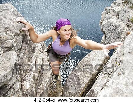 Stock Photography - Climber scaling rock formation. Fotosearch