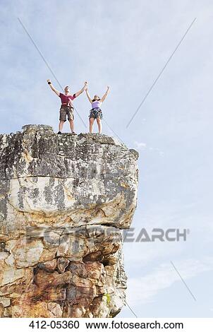 Climbers cheering on rocky cliff View Large Photo Image Stock Image - Climbers cheering on rocky cliff. Fotosearch