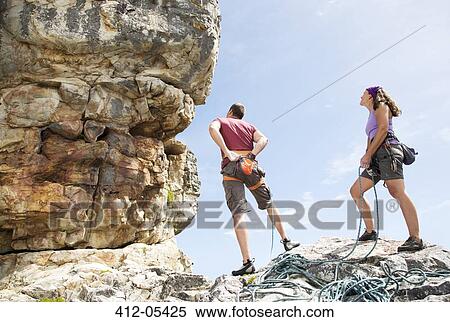 Climbers examining rock formation View Large Photo Image Stock Photography - Climbers examining rock formation. Fotosearch