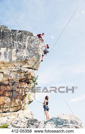 Climbers scaling steep rock face View Large Photo Image Stock Photo - Climbers scaling steep rock face. Fotosearch
