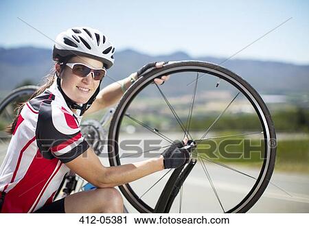 Cyclist adjusting tires on rural road View Large Photo Image Stock Image - Cyclist adjusting tires on rural road. Fotosearch