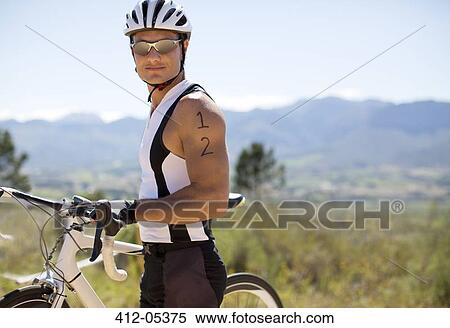 Stock Photography - Cyclist standing on rural road. Fotosearch
