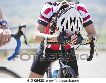 Stock Image - Disappointed cyclist resting on handlebars. Fotosearch