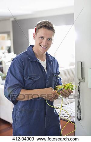 Stock Photo - Electrician working on telephone in home. Fotosearch