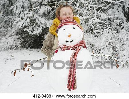 Stock Photo - Girl making snowman outdoors. Fotosearch