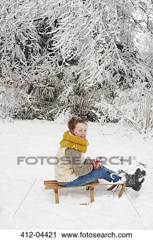 Girl sitting on wooden sled in snow View Large Photo Image Stock Image - Girl sitting on wooden sled in snow. Fotosearch