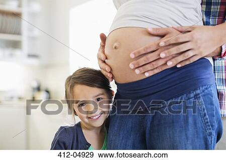 Girl smiling with pregnant mother's bell View Large Photo Image Stock Photo - Girl smiling with pregnant mother's bell. Fotosearch