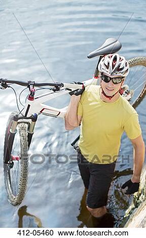 Man carrying mountain bike in river View Large Photo Image Stock Image - Man carrying mountain bike in river. Fotosearch