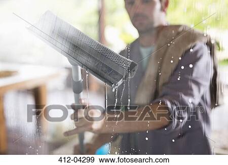 Stock Photo - Man washing window with squeegee. Fotosearch