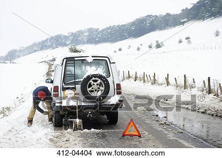 Man working on broken down car in snow View Large Photo Image Picture - Man working on broken down car in snow. Fotosearch