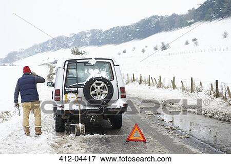 Man working on broken down car in snow View Large Photo Image Stock Photo - Man working on broken down car in snow. Fotosearch