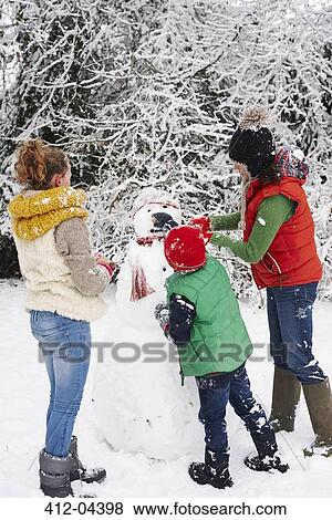 Mother and children making snowman outdoors View Large Photo Image Stock Photo - Mother and children making snowman outdoors. Fotosearch