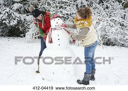 Stock Photo - Mother and daughter making snowman. Fotosearch