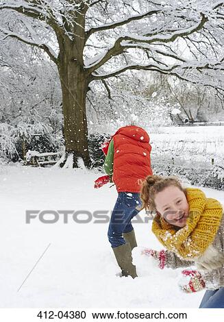 Stock Image - Mother and daughter playing in snow. Fotosearch
