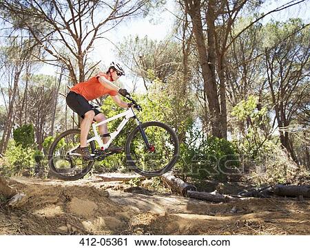 Stock Image - mountain biker on dirt path. Fotosearch