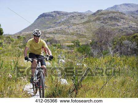 Stock Photograph - mountain biker on dirt path. Fotosearch