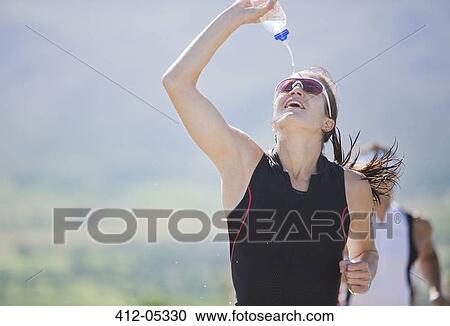 Stock Image - Runner spraying water in race. Fotosearch