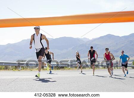Runners crossing race finish line View Large Photo Image Stock Photo - Runners crossing race finish line. Fotosearch