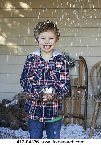 Smiling boy playing in snow View Large Photo Image Stock Photograph - Smiling boy playing in snow. Fotosearch