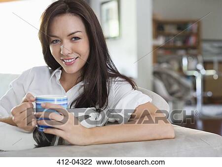 Stock Image - Smiling woman drinking cup of coffee. Fotosearch