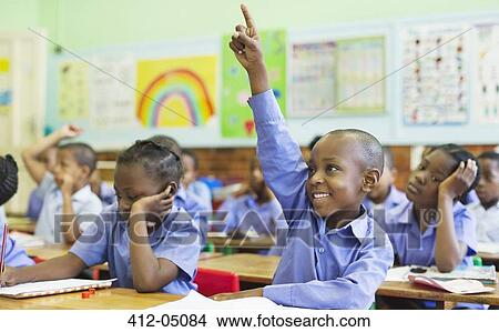 Picture - Student raising hand in class. Fotosearch