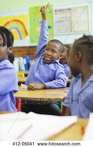 Stock Image - Student raising hand in class. Fotosearch