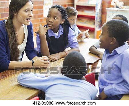 Stock Image - Students and teacher talking in class. Fotosearch